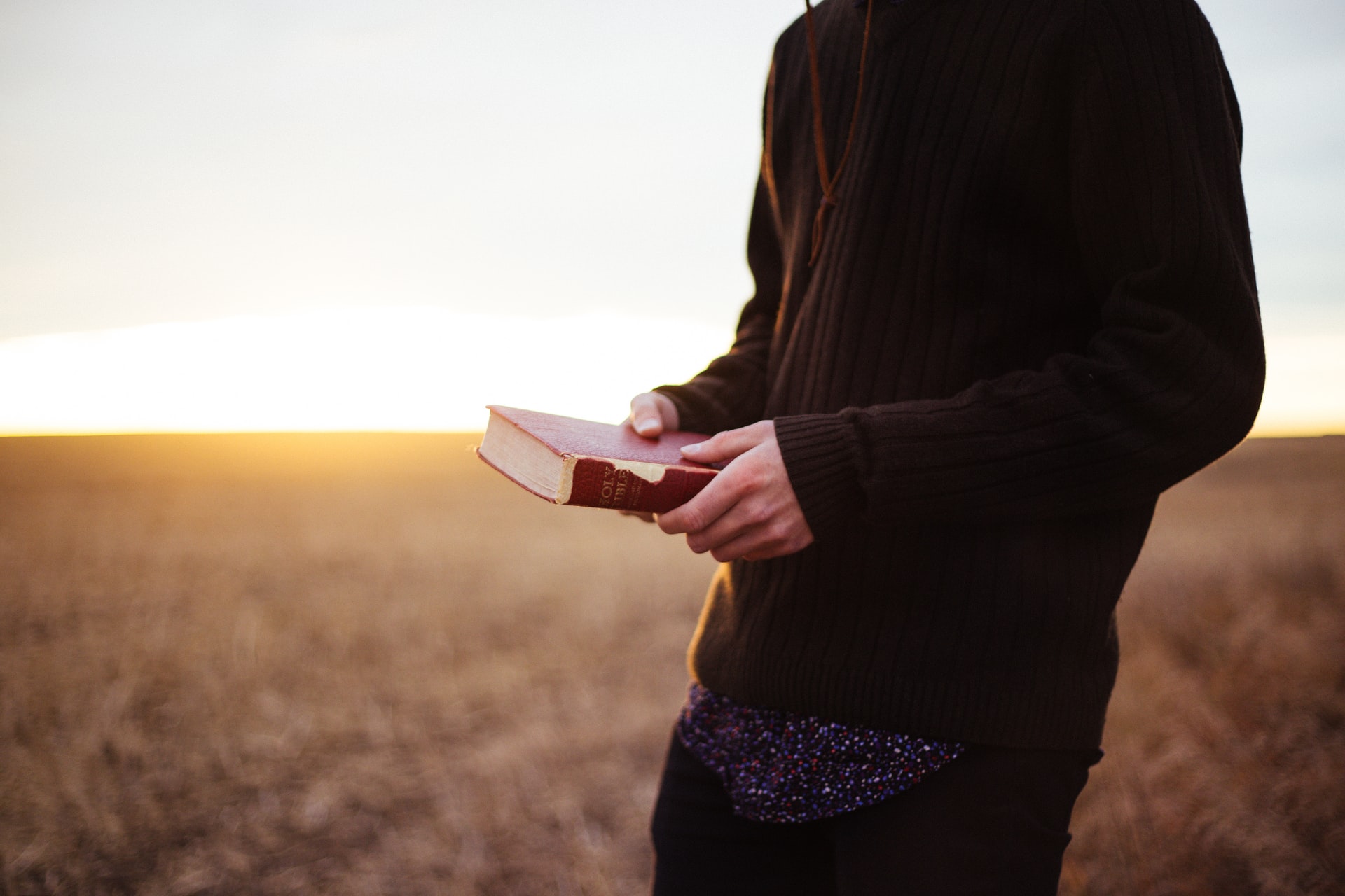 Man with bible sunset